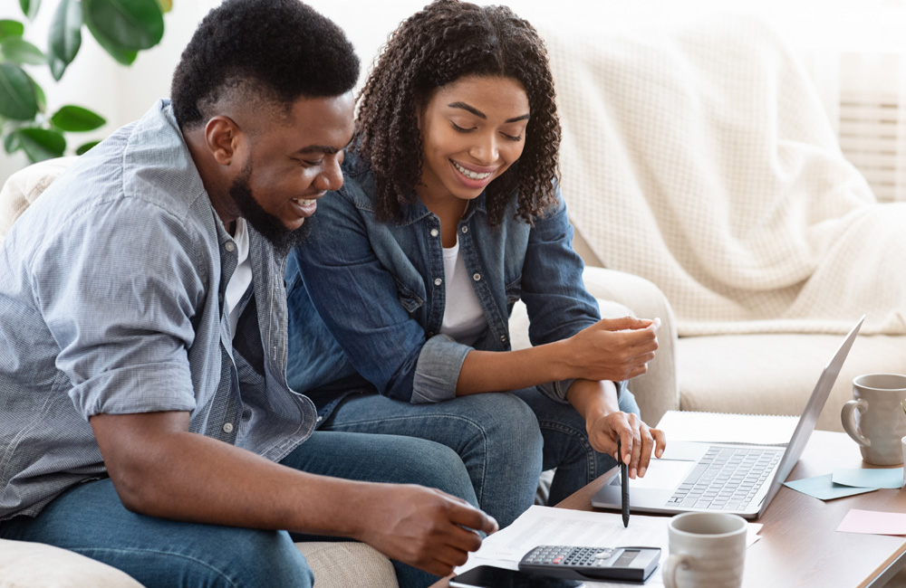 Young couple smiling and using a calculator