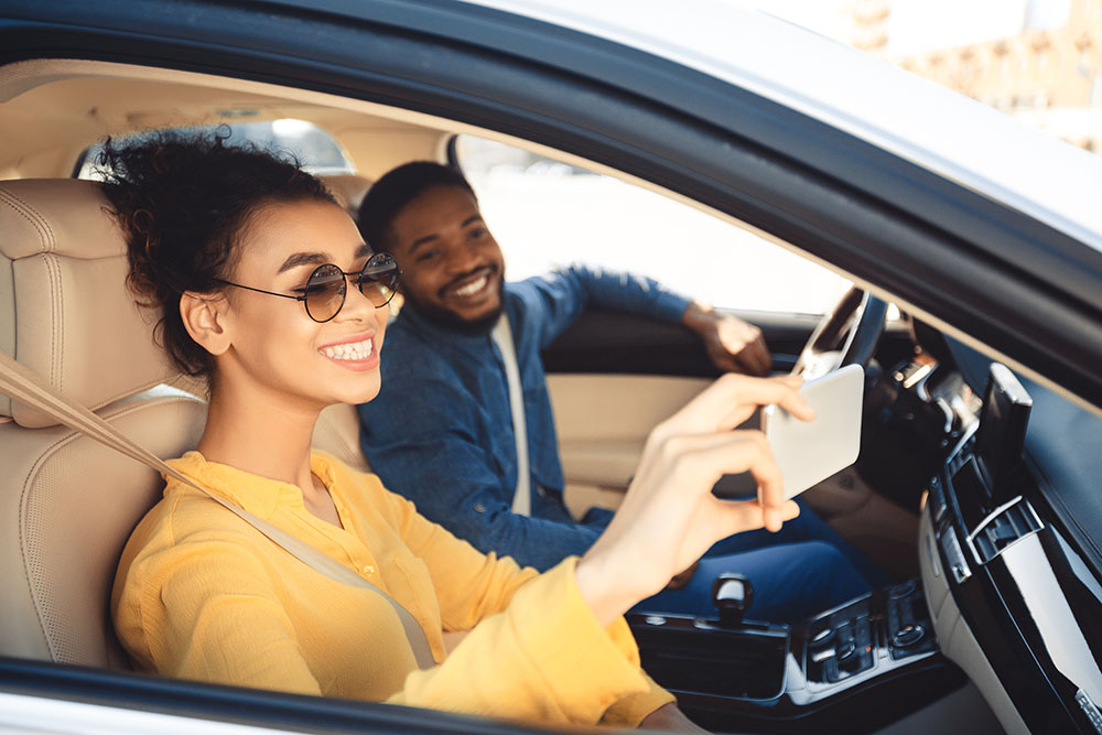 Young smiling couple taking a selfie in the car