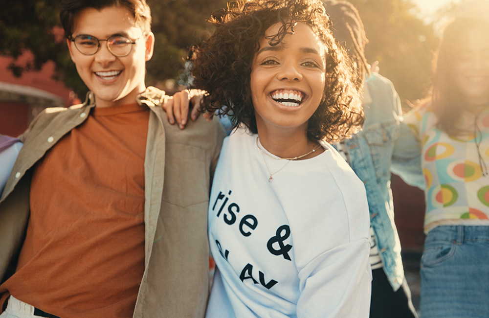 Young couple smiling with a group of friends in the background