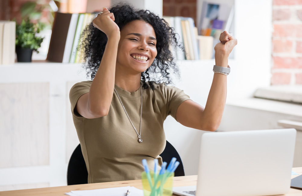 Person celebrating while using a laptop