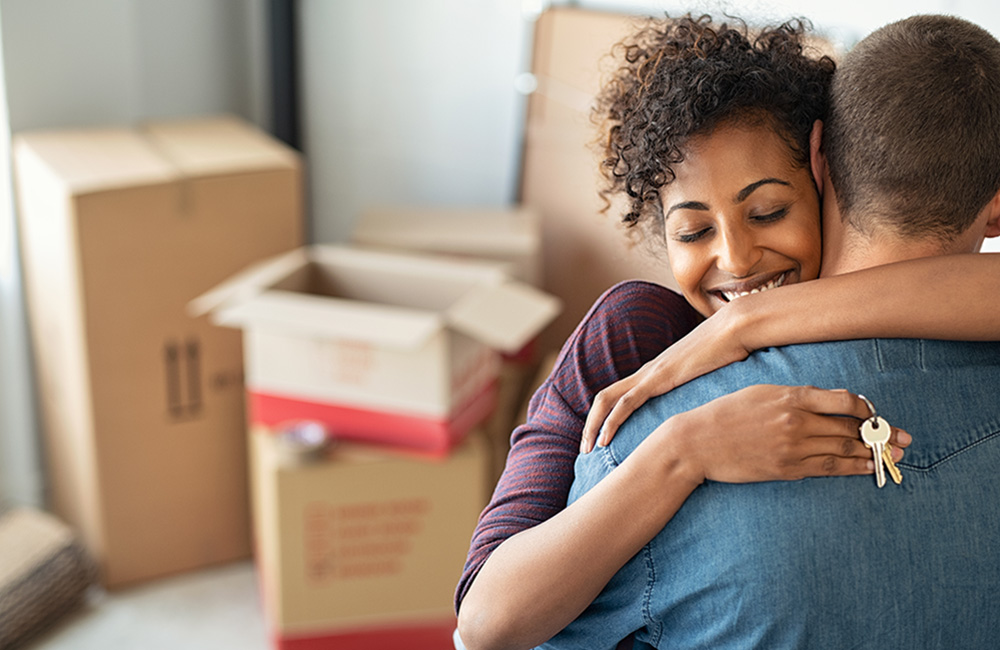Couple celebrating inside their new home while holding house keys