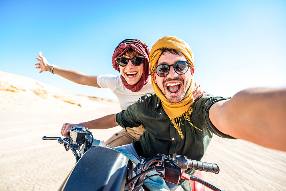 Smiling couple on a motorcycle enjoying their adventure