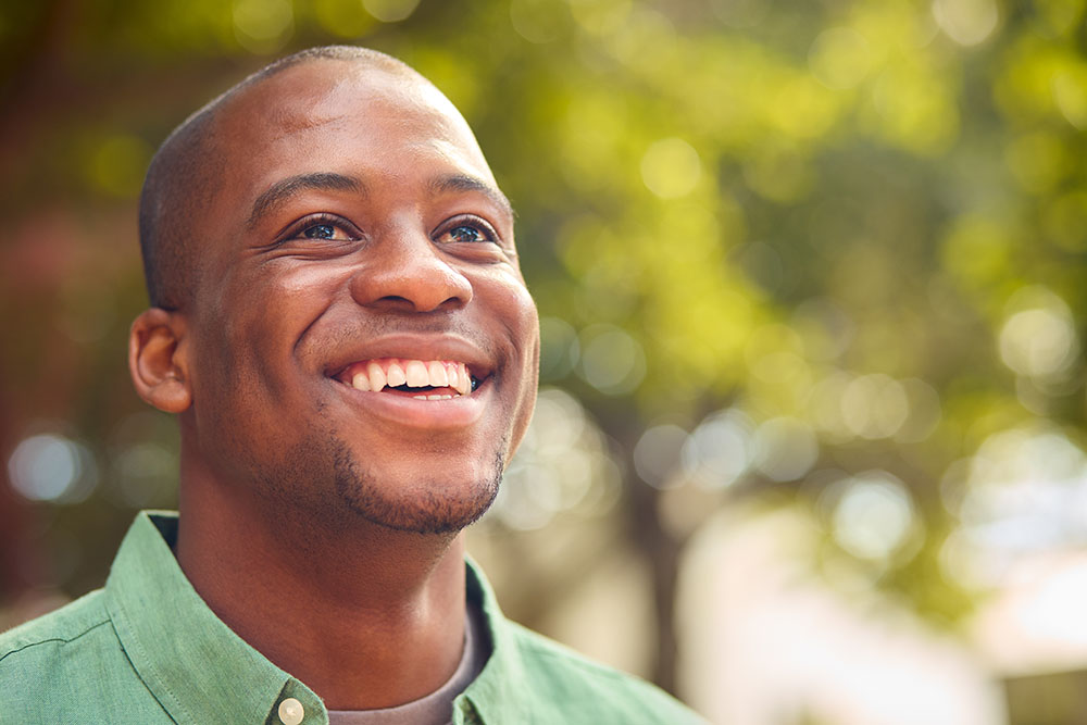 Smiling person outdoors looking upward