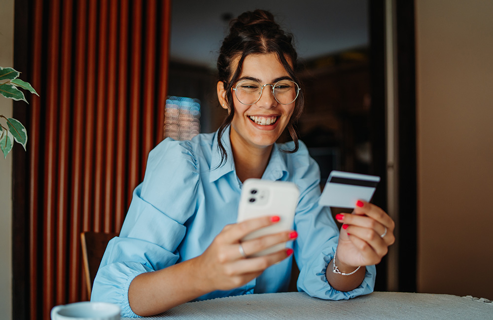 Person using a smartphone while holding a payment card