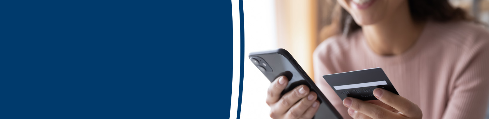 Person using a smartphone while holding a payment card