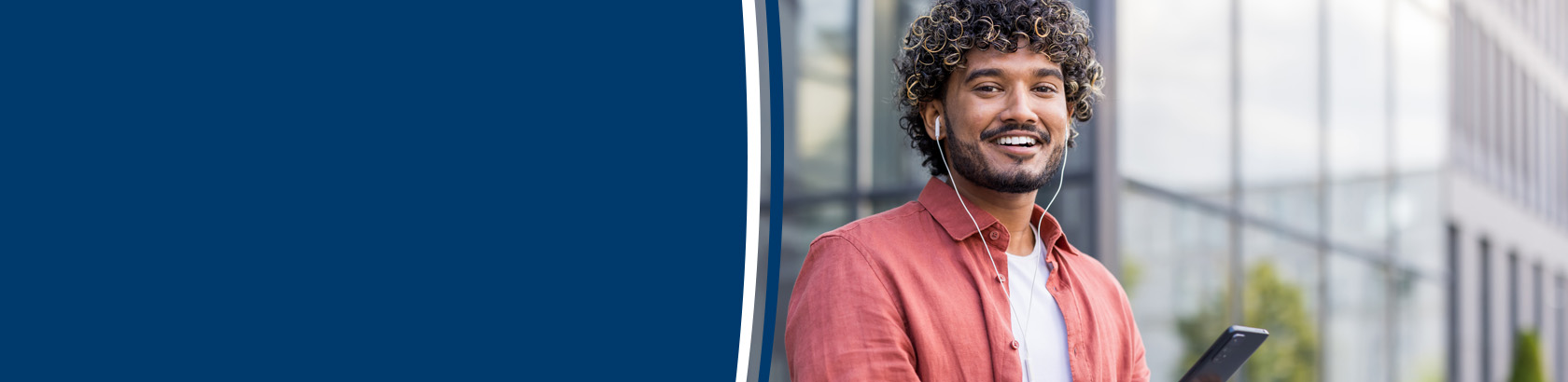 Smiling person wearing earbuds outdoors