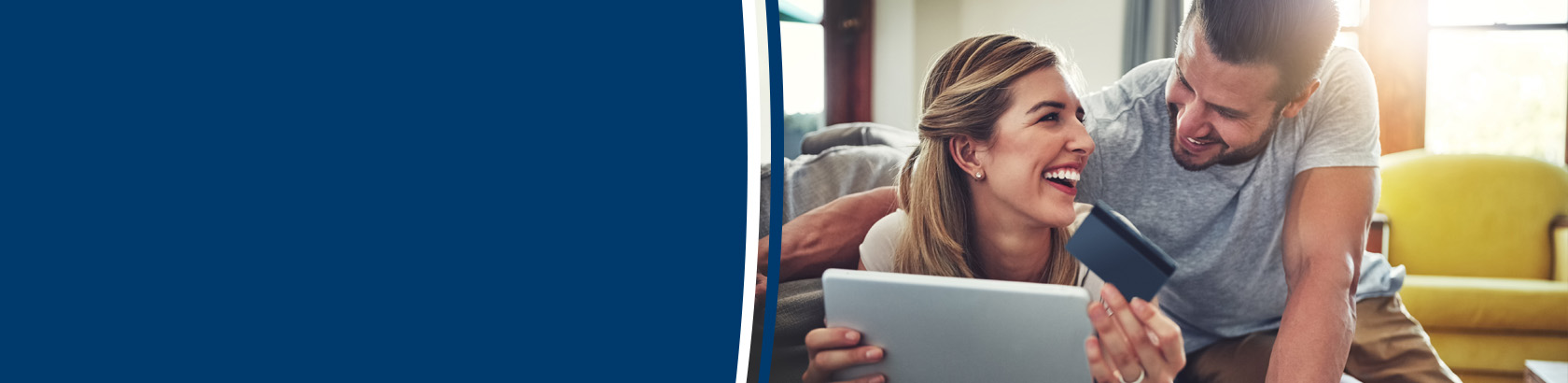 Couple using a tablet and payment card together at home