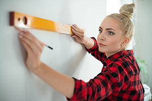 Woman using a level on the wall