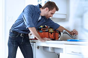 Man fixing the faucet in the house