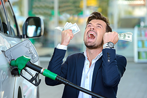 Man holding dollar bills by a fuel pump