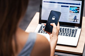 Woman holding a smart phone with a lock on the screen