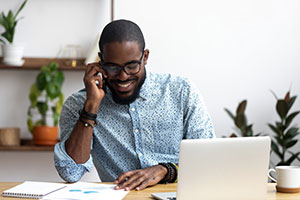 A man with a laptop and a mobile phone