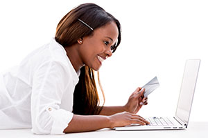 A woman with a laptop and a payment card