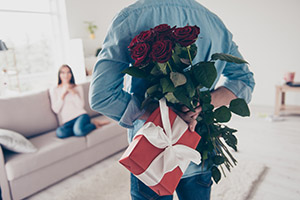 Man with flowers and gift on Valentine's Day