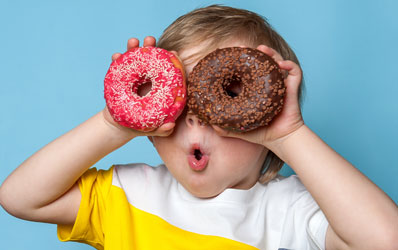 Child excited looking through the donut holes as binoculars